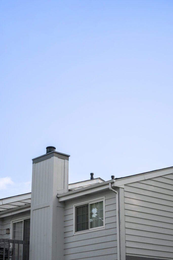 Exterior house wall, chimney, blue sky. | The Bearded Contractor