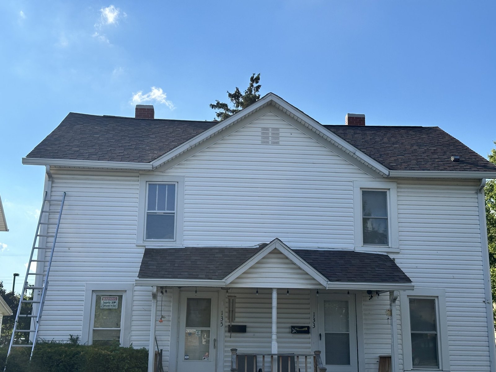White two-story house with ladder | The Bearded Contractor